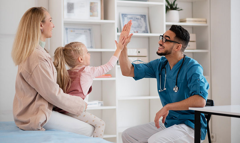 Young patient giving her Direct Primary Care doctor a high-five during a family visit at Primary Health Partners